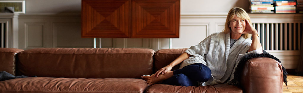 Confident woman on couch in her home