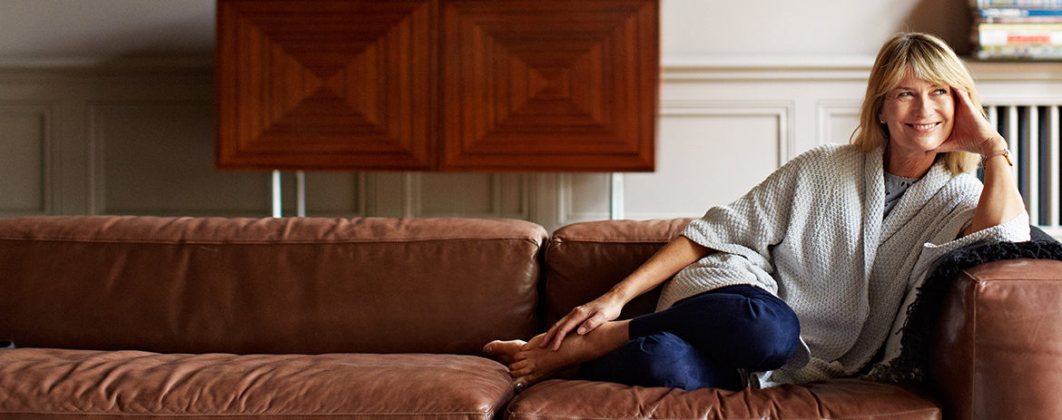 Confident woman on couch in her home