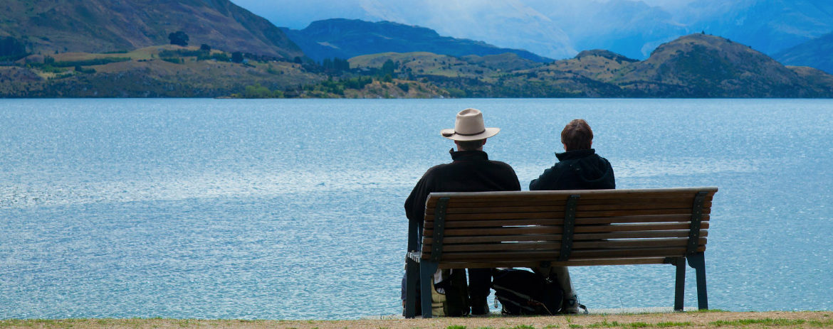 Retired couple sitting on chair looking out at Lake Wanaka