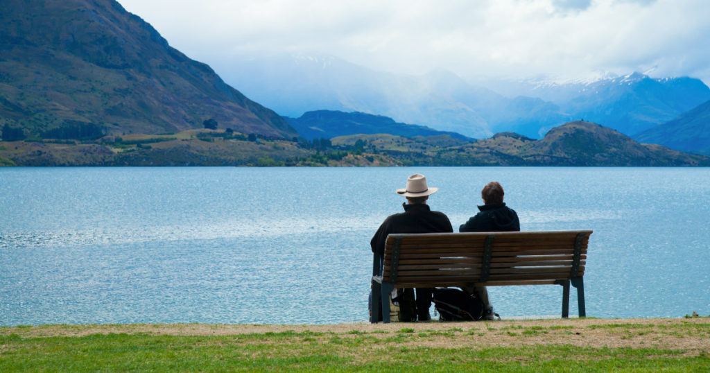 Retired couple sitting on chair looking out at Lake Wanaka