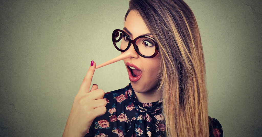 Young woman looking astonished at her growing nose