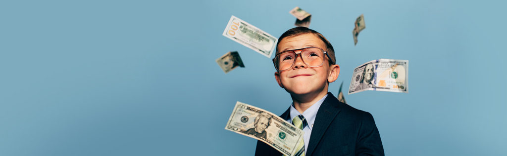 Young boy posing with money drifting around him